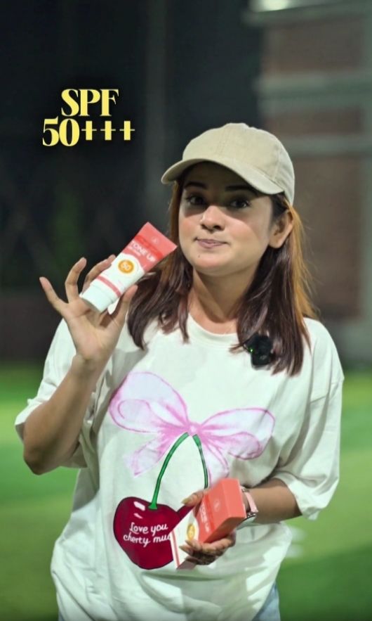 A woman holds a bottle of MEDB Daylight Tone Up Sun Cream, promoting MedB Daylight Tone Up Sun Cream for skincare in Bangladesh.